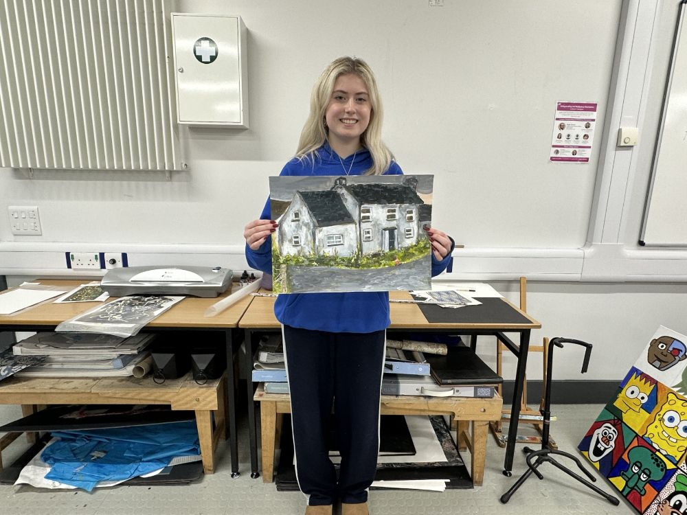 Student Anna Clarke in the SERC art studio, holding one of her paintings